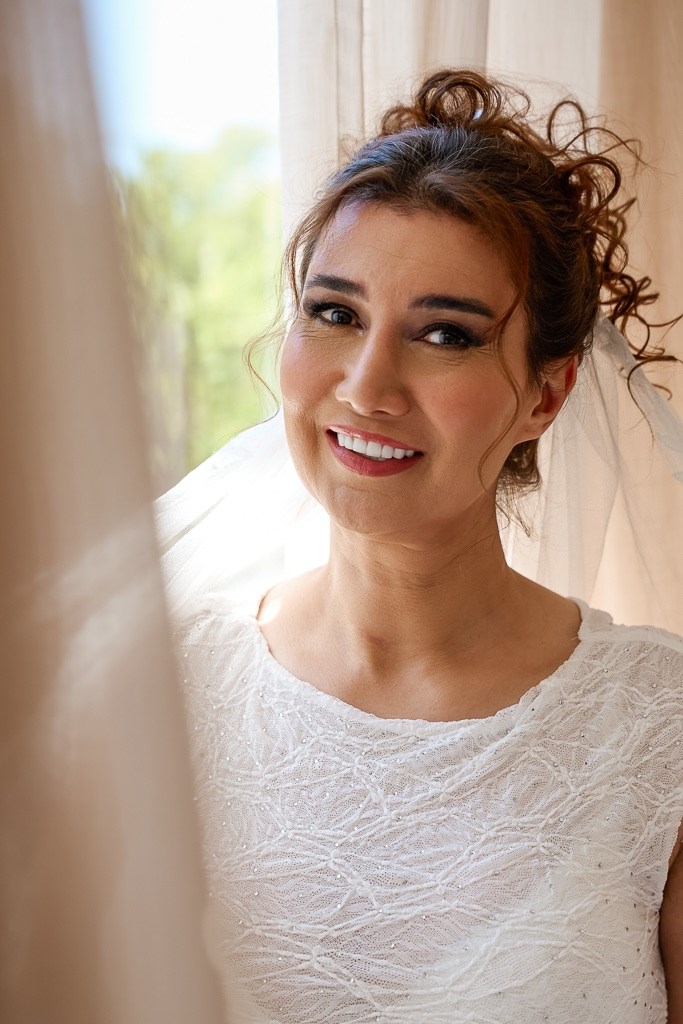 Model lächelt am Fenster mit Schleier