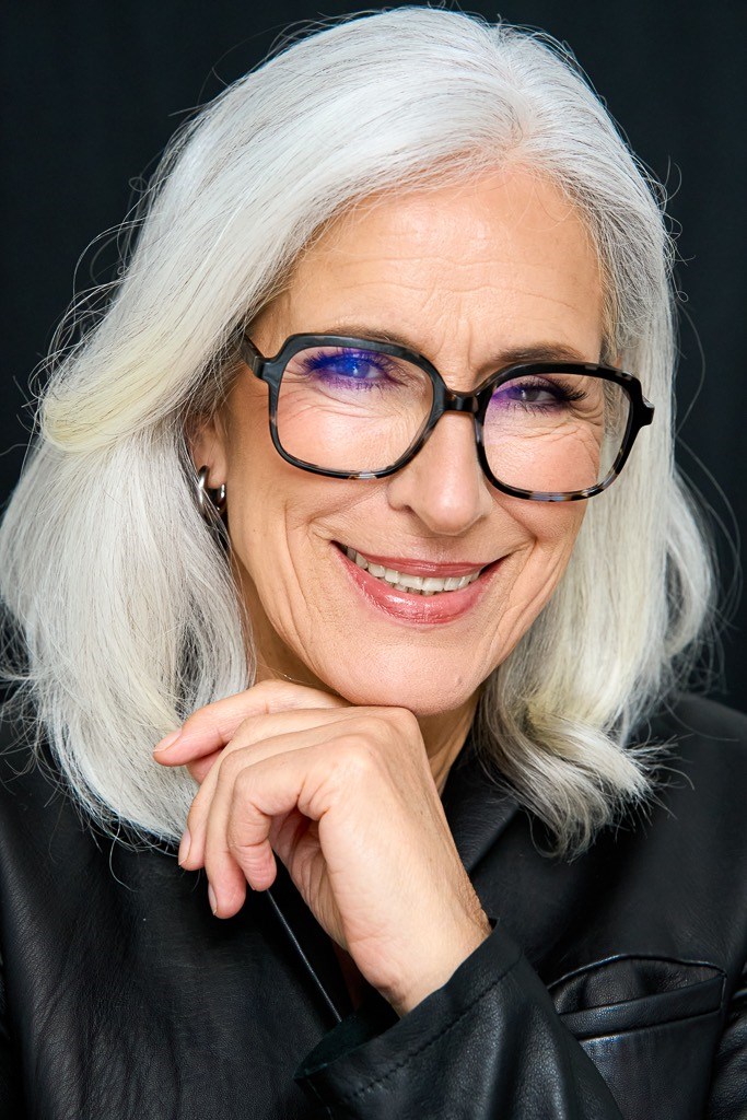 Best Ager Model mit dunkler Brille lacht in die Kamera